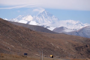 Ein Laster fährt auf dem Friendship Highway, im Hintergrund erheben sich die Berge.