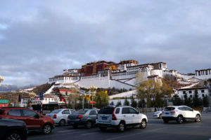 Autos stehen vor dem Potala-Palast in Lhasa in Tibet an der Ampel.