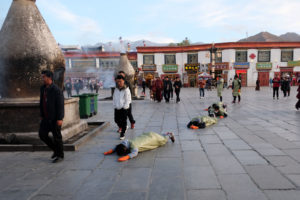 Eine Gruppe junger Tibeter betet auf dem Barkhor mit vollem Körpereinsatz.