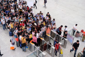 Menschen stehen in langen Schlangen vor den Eincheckschranken, um zu ihrem Zug in Nanning in China zu gelangen.