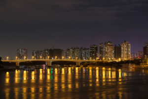 Beleuchtete Hochhäuser leuchten über den Fluss hinweg in Nanning in China.