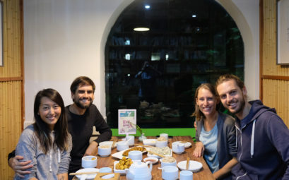 Leo und Sebastian sitzen mit ihren Couchsurfing-Gastgebern Hailey und Narayan im Restaurant.