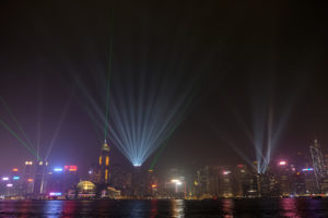 Für die Lightshow in Hongkong leuchten riesige Scheinwerfer von den Hochhäusern.
