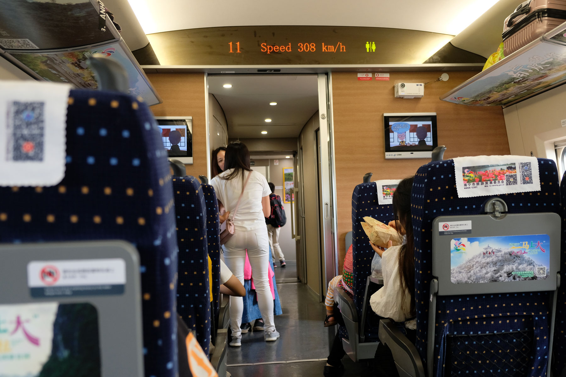 Zwei Frauen stehen im Gang des Schnellzugs, der trotz 308 km/h erschütterungsfrei durch den Osten Chinas fliegt.