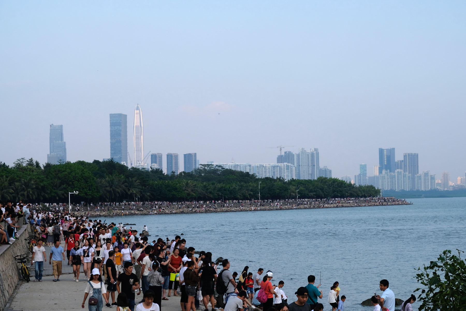 Am chinesischen Nationalfeiertag spazieren hunderte Menschen entlang der Bucht von Shenzhen.