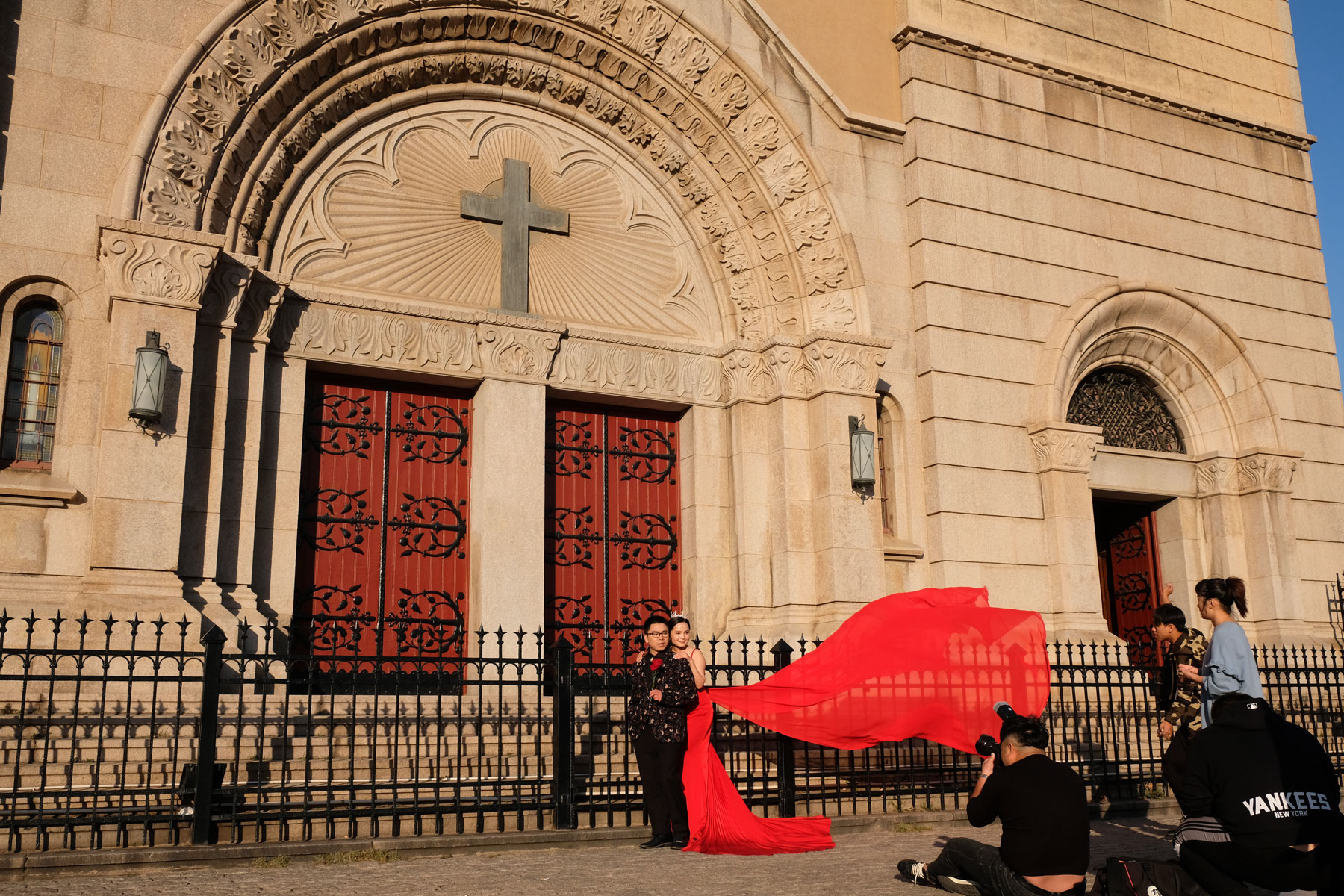 Ein Brautpaar lässt sich vor der Sankt Michaels Kirche in Qingdao in China fotografieren.