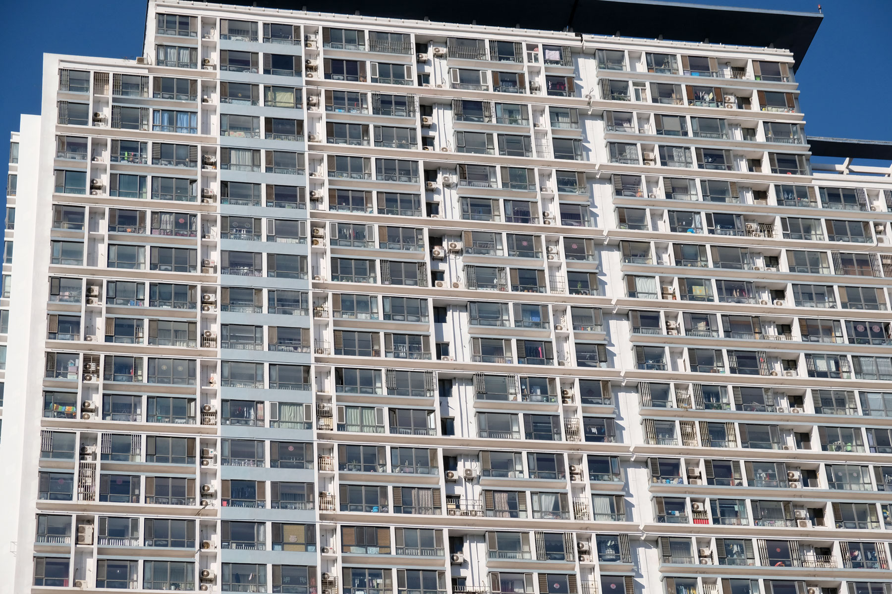 Die Fensterfassade eines Hochhauses in Qingdao in China.