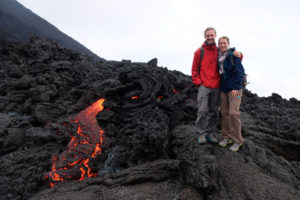 Leo und Sebastian stehen einen Meter entfernt von rot glühendem, heißen Magma am Vulkan Pacaya in Guatemala.