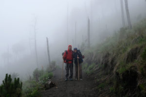 Leo und Sebastian stehen im Nebel, als sie auf den Vulkan Acatenango in Guatemala wandern.