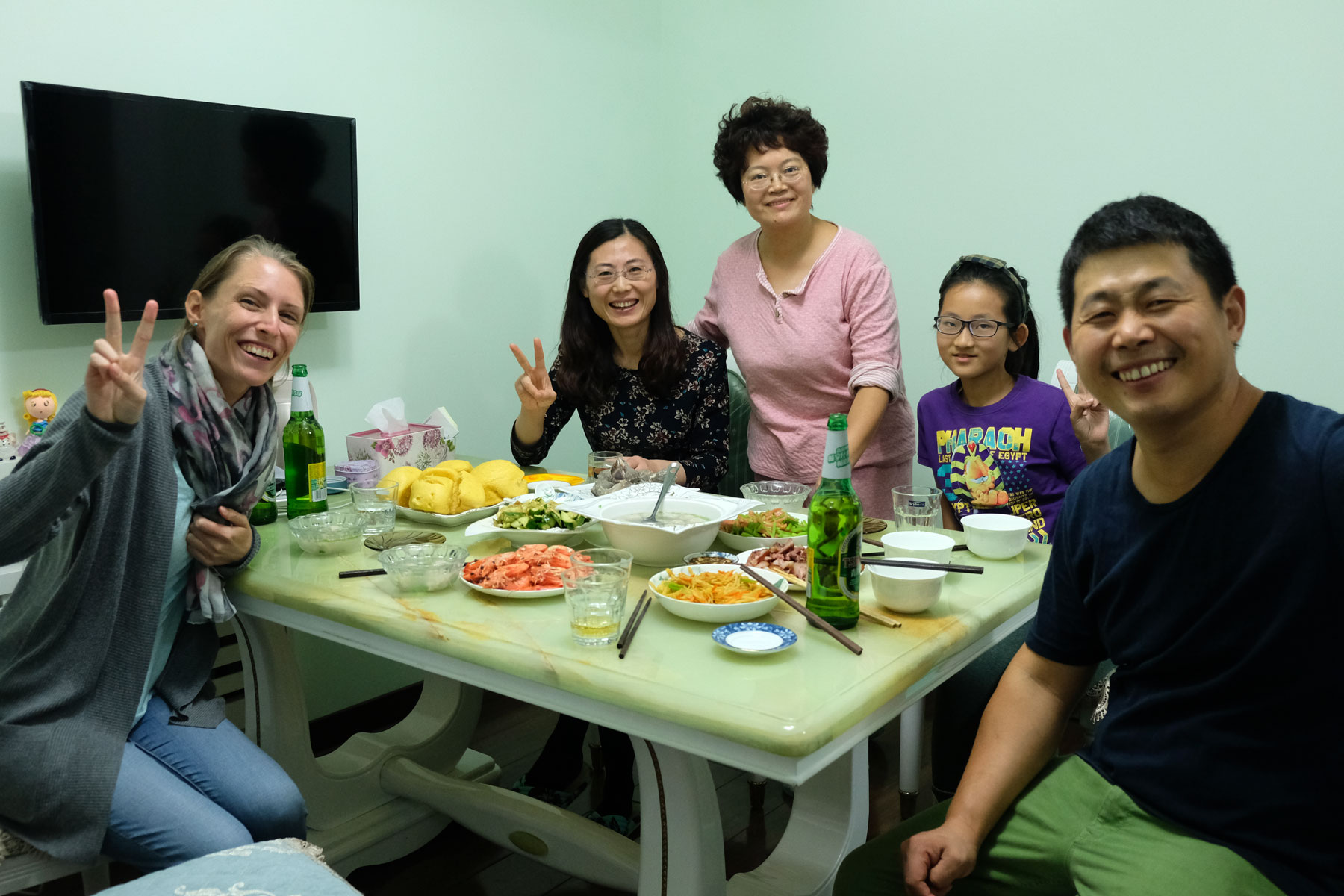 Leo sitzt mit den Gastgebern zusammen am Abendessenstisch in Qingdao, China.