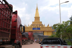 Eine Stupa und Lastwagen am Grenzübergang Mohan zwischen China und Laos.