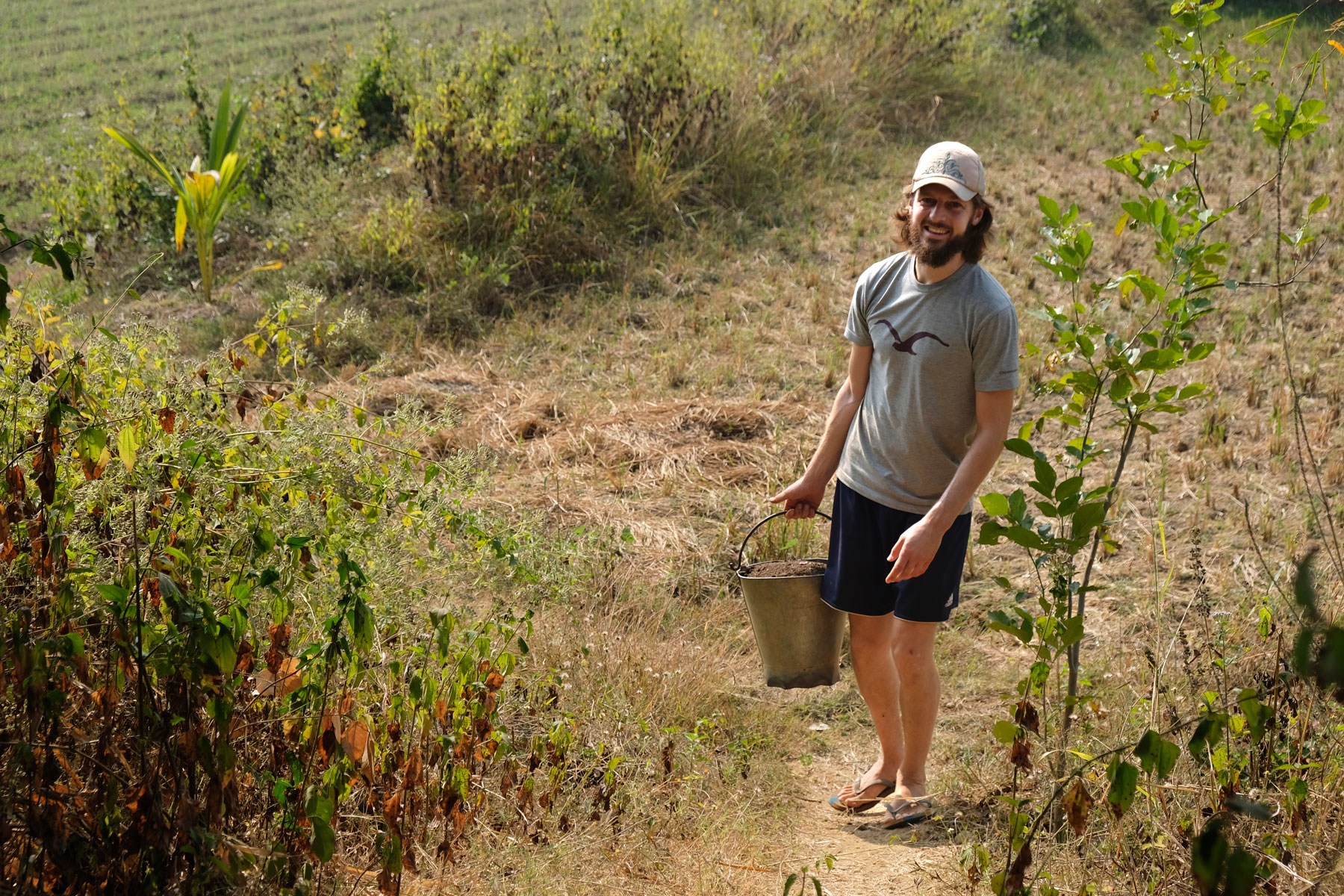 Sebastian trägt beim Workaway in Indien einen Eimer mit Erde.