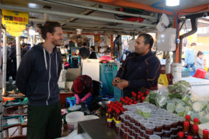 Sebastian unterhält sich mit einem Verkäufer am Fischmarkt in Gonggu in Südkorea.