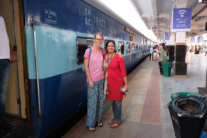 Leo steht mit einer Frau neben einem Zug im Bahnhof von Hyderabad.
