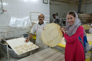 Leo mit einem Brot in Herzform in einer iranischen Bäckerei.