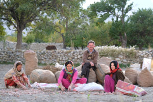 Menschen sitzen auf einem Feld in Pakistan und ernten Kartoffeln.