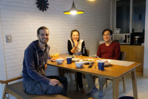 Sebastian sitzt mit unseren Couchsurfing-Gastgebern in Südkorea am Esstisch.