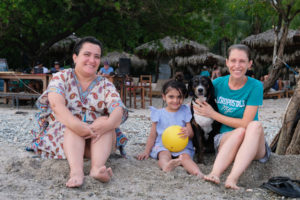 Leo sitzt mit ihrer Namensschwester am Strand Santa Teresa in Costa Rica.