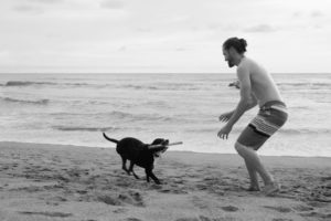 Sebastian spielt mit unserem House Sitting Hund Max am Strand von Costa Rica.