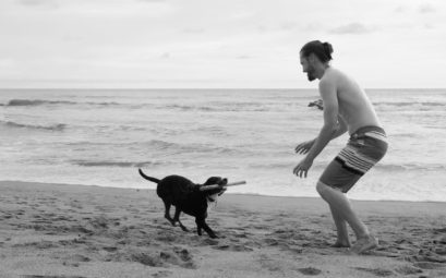 Sebastian spielt mit unserem House Sitting Hund Max am Strand von Costa Rica.