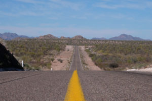 Eine Straße zieht sich durch die Weite der Baja California in Mexiko.