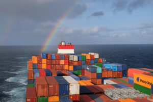 Hinter unserem Containerschiff leuchtet ein Regenbogen über dem Atlantik.