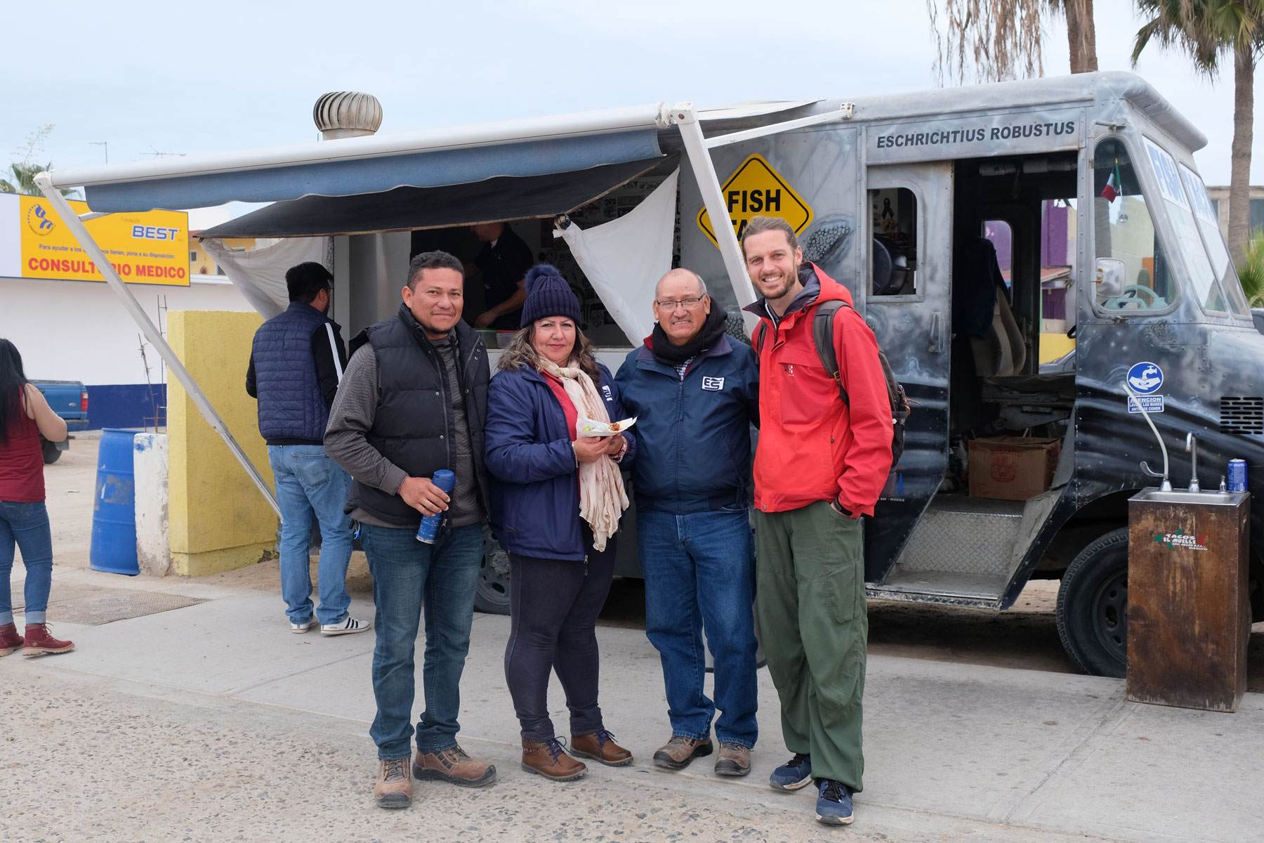 Sebastian steht mit unseren Couchsurfing-Gastgebern vor einem Tacostand in Mexiko.
