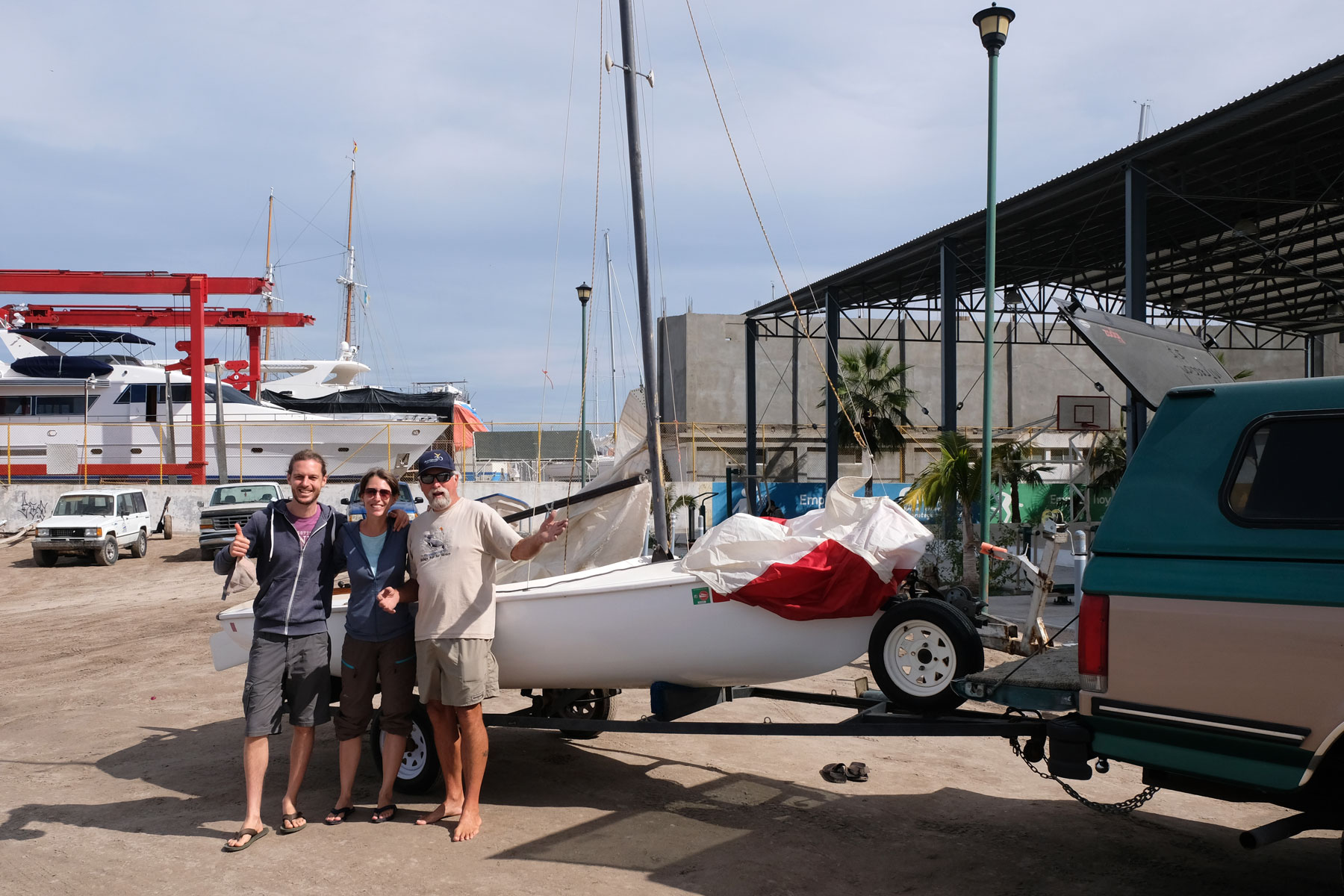 Mit Steve stehen Leo und Sebastian vor einem kleinen Segelboot in La Paz in Mexiko.
