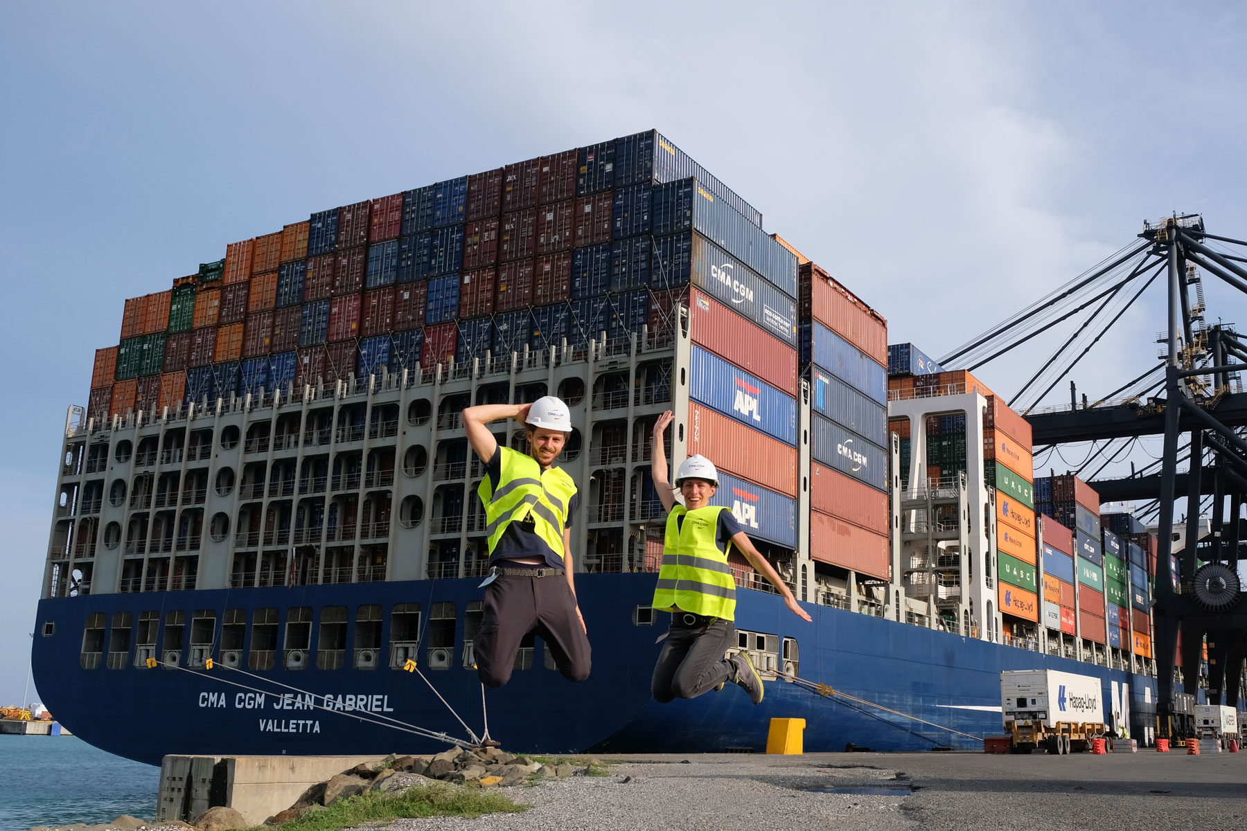 Leo und Sebastian springen vor dem Containerschiff am Hafen Caucedo in die Luft.