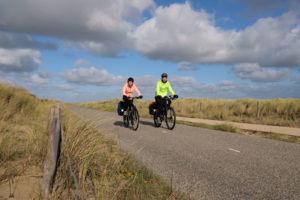 Leo und Sebastian fahren mit ihren Fahrrädern durch die Dünen der Niederlande.