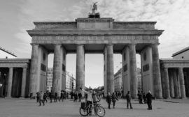 Leo und Sebastian stehen mit ihrem Fahrrad vor dem Brandenburger Tor in Berlin.
