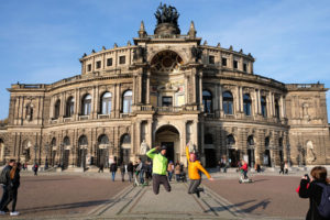 Leo und Sebastian springen vor der Semperoper in Dresden in die Luft.