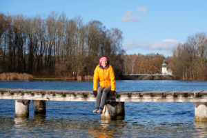 Leo sitzt auf einem Holzsteg am Kuhsee in Augsburg.