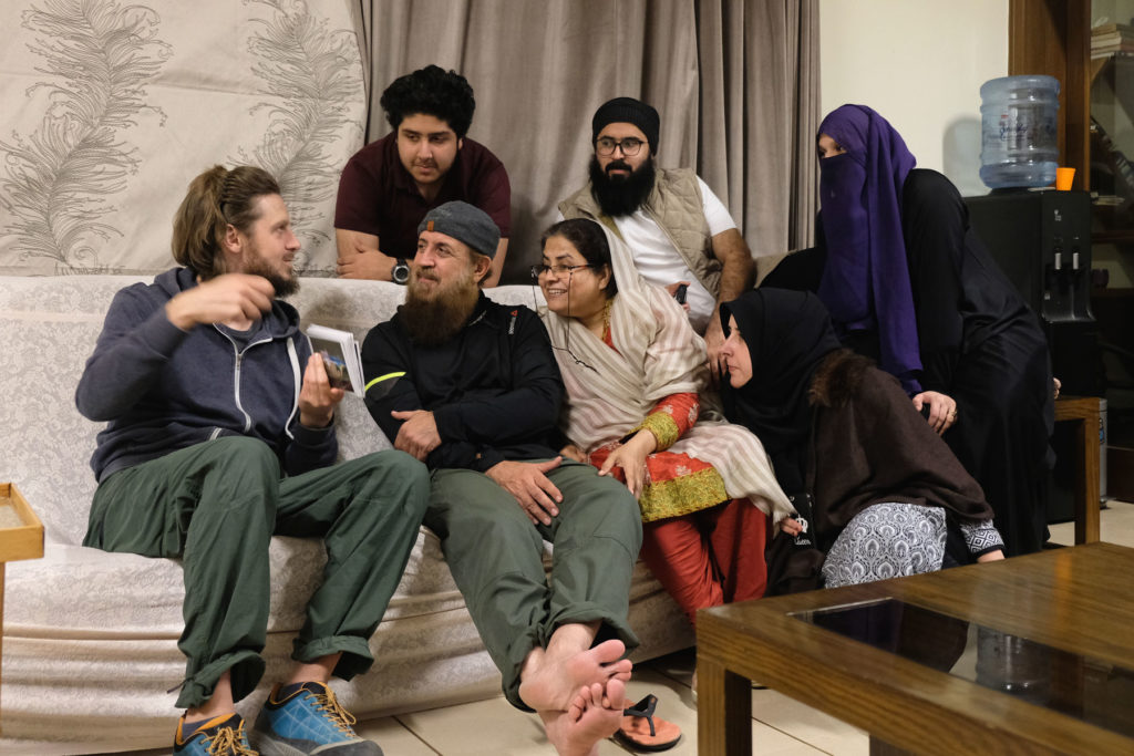 Sebastian zeigt einer pakistanischen Familie ein Fotoalbumb mit Bildern aus Deutschland.
