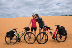 Leo und Sebastian stehen mit ihren Fahrrädern auf einer Sanddüne in Vietnam.
