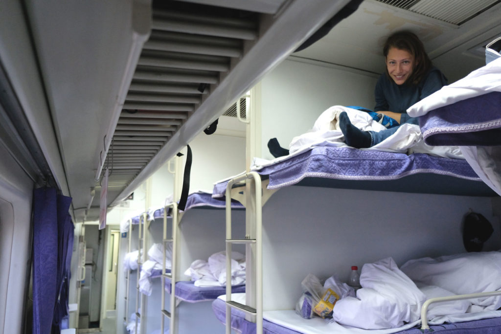 Leo sitzt im Bett eines Nachtzuges in China.